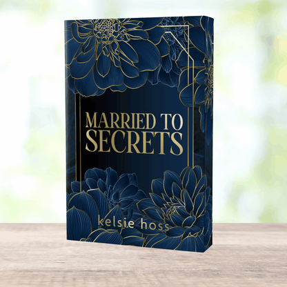 A copy of Married to Secrets by Kelsie Hoss with wraparound black and gold design. 