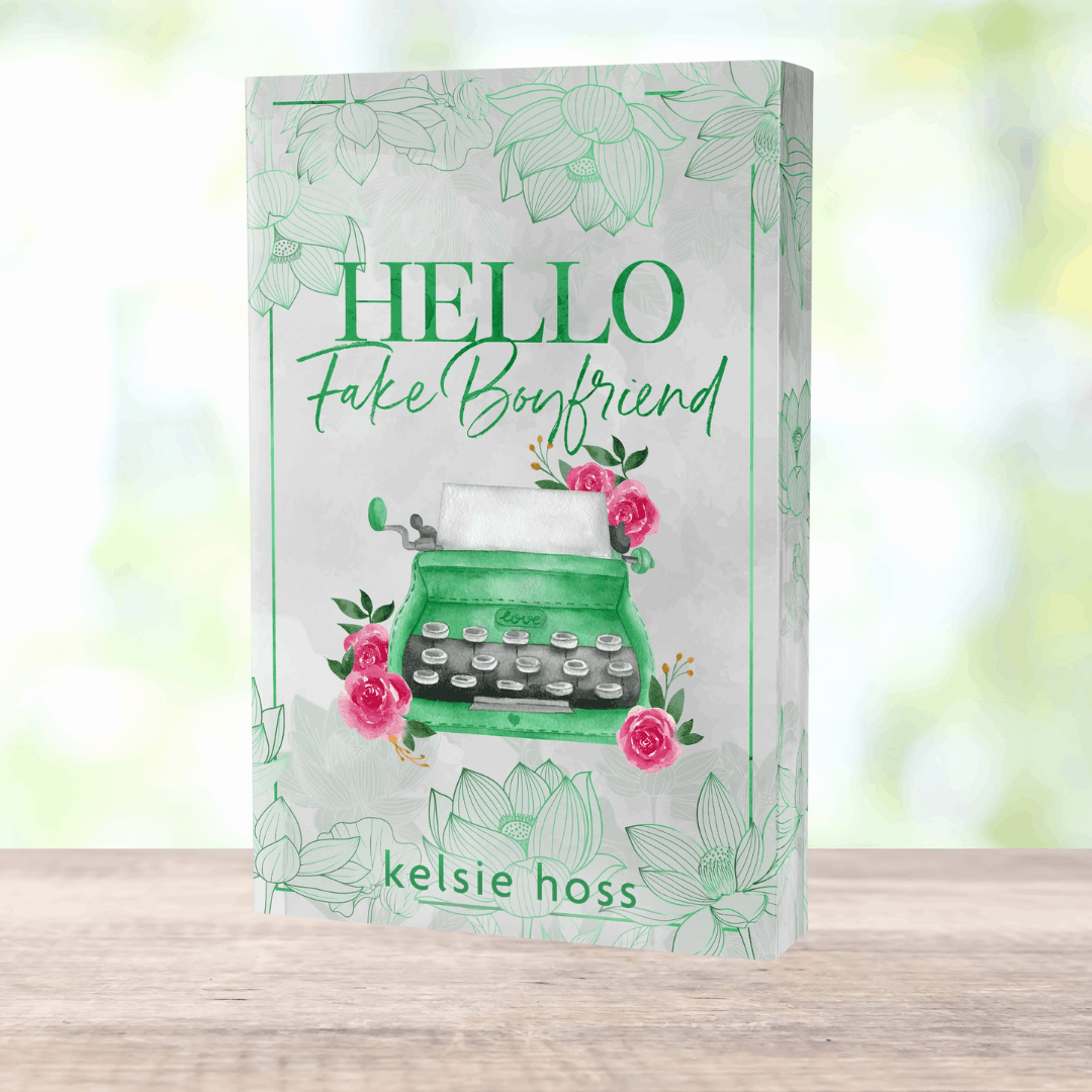 a paperback copy of Hello Fake Boyfriend by Kelsie Hoss, the cover features a green typewriter 