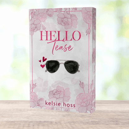 a paperback copy of Hello Tease by Kelsie Hoss, the cover features a pair of sunglasses 