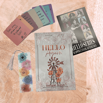 Book titled 'Hello Again' by Kelsie Hoss with a bookmark and other items on a wooden surface.